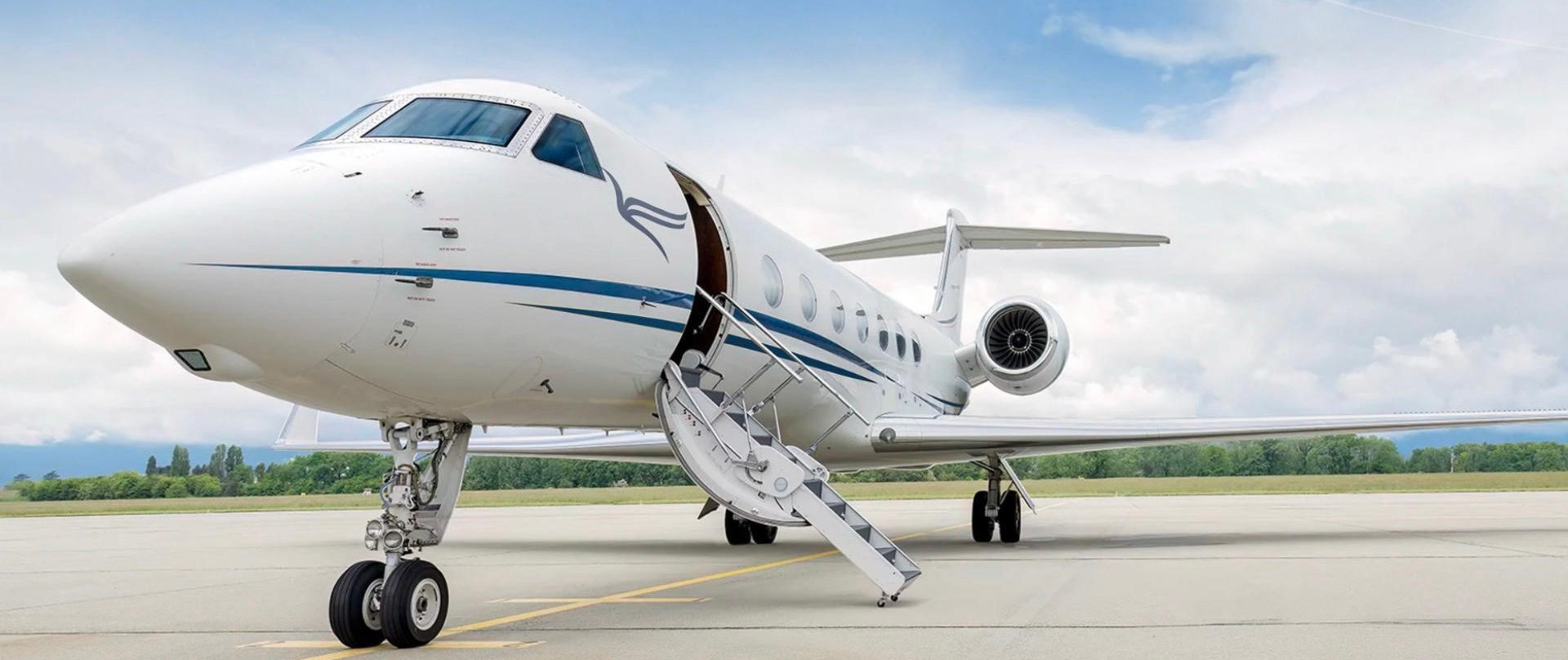 Privatjet weiß auf Startbahn geparkt mit ausgefahrener Treppe unter bewölktem Himmel